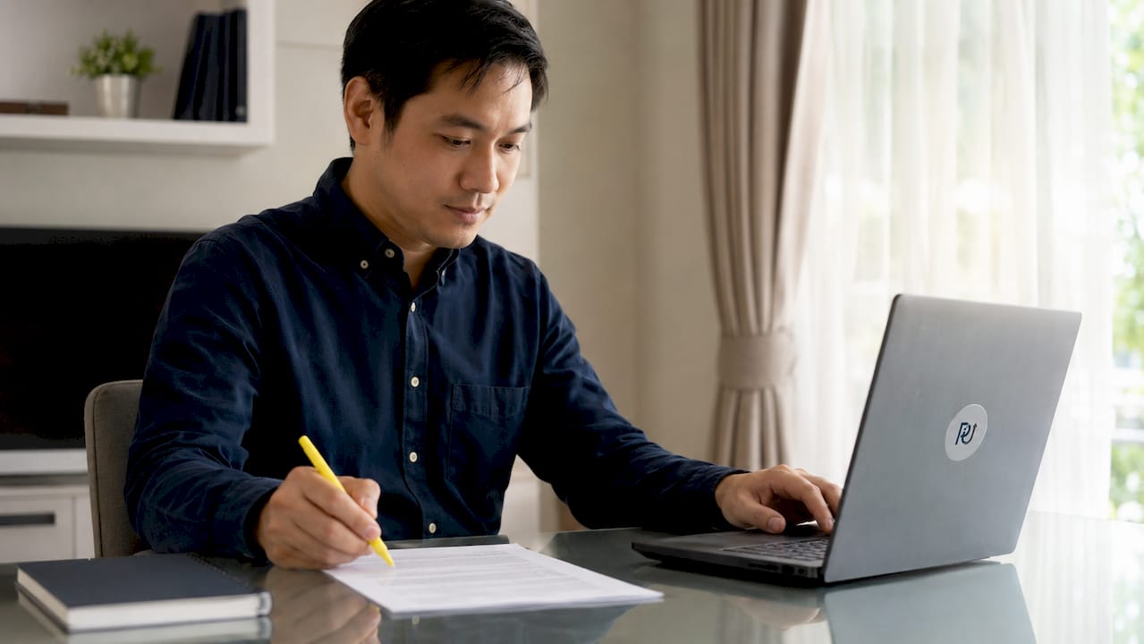 Close-up of hands highlighting contract with laptop